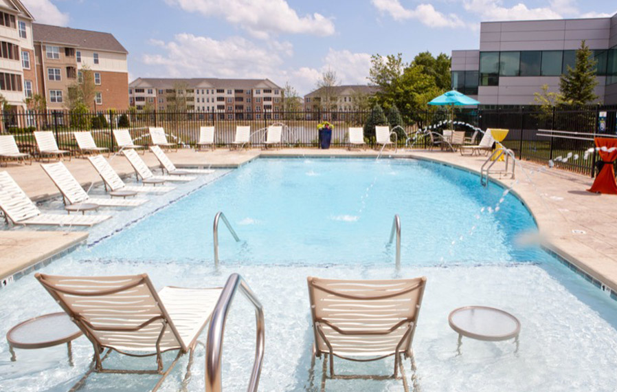 A beautiful blue pool enhances your apartment experience in Fishers. Lake side pool on a sunny day.